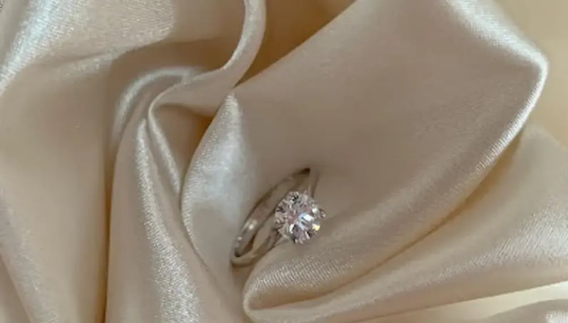 diamond engagement ring on white cloth 